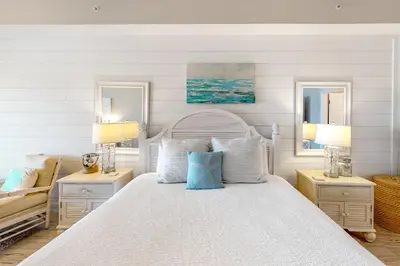 a white bedroom with a white bed and two lamps at Amazing views at this renovated 4rth-floor condo with lagoon pool & pickleball in Santa Rosa Beach