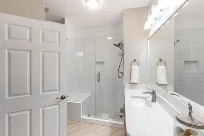 a white bathroom with a shower and a sink at Amazing views at this renovated 4rth-floor condo with lagoon pool & pickleball in Santa Rosa Beach