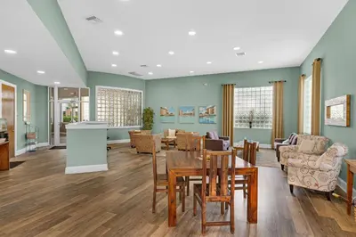 a living room with a table and chairs at Amazing views at this renovated 4rth-floor condo with lagoon pool & pickleball in Santa Rosa Beach