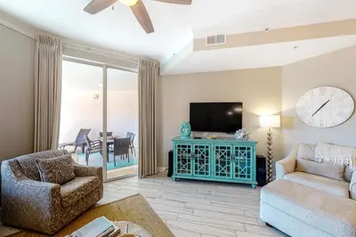 a living room with a couch and a tv at Amazing views at this renovated 4rth-floor condo with lagoon pool & pickleball in Santa Rosa Beach