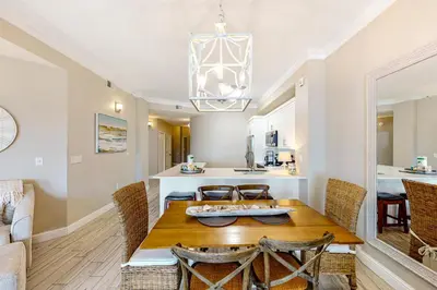 a dining room and kitchen with a table and chairs at Amazing views at this renovated 4rth-floor condo with lagoon pool & pickleball in Santa Rosa Beach