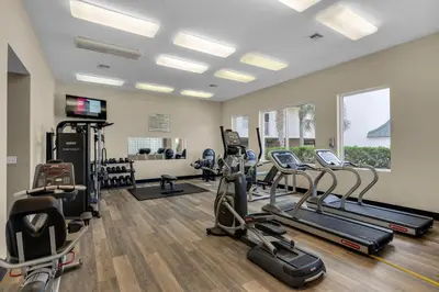 a gym with treadmills and cardio equipment in a room at 4th-floor condo with beach ambience lagoon pool gym tennis & pickleball in Santa Rosa Beach