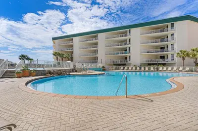 a swimming pool in front of a large building at Gorgeous condo with pool & Gulf view stunning decor bunk beds & pickleball in Santa Rosa Beach