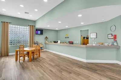 a waiting room with a table and chairs and a counter at Gorgeous condo with pool & Gulf view stunning decor bunk beds & pickleball in Santa Rosa Beach