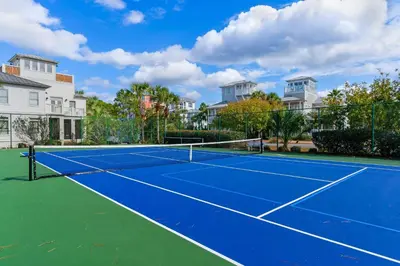 a tennis court in front of some houses at Super-comfy Seagrove condo with spacious pool-view balcony & pickleball in Santa Rosa Beach