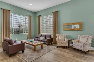 a living room with chairs and a table at Super-comfy Seagrove condo with spacious pool-view balcony & pickleball in Santa Rosa Beach