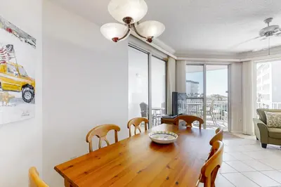 a dining room with a wooden table and chairs at Super-comfy Seagrove condo with spacious pool-view balcony & pickleball in Santa Rosa Beach