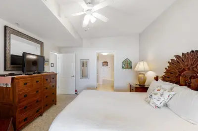 a bedroom with a bed and a television on a dresser at Super-comfy Seagrove condo with spacious pool-view balcony & pickleball in Santa Rosa Beach