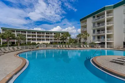 a swimming pool in front of a resort at Attractive home with spacious balcony pool view & pickleball - near beach in Santa Rosa Beach
