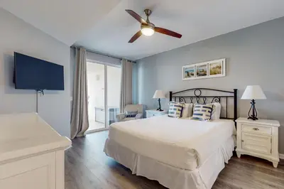a bedroom with a bed and a ceiling fan at Attractive home with spacious balcony pool view & pickleball - near beach in Santa Rosa Beach