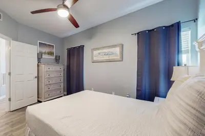 a bedroom with a bed and a ceiling fan at Attractive home with spacious balcony pool view & pickleball - near beach in Santa Rosa Beach
