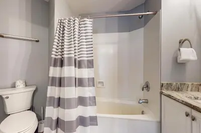 a bathroom with a shower curtain and a toilet at Attractive home with spacious balcony pool view & pickleball - near beach in Santa Rosa Beach
