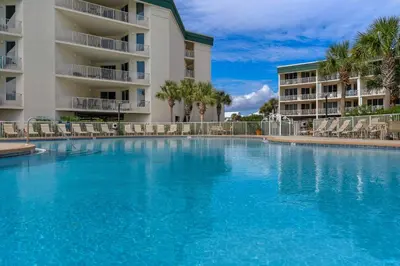 a large swimming pool in front of a building at Attractive home with spacious balcony pool view & pickleball - near beach in Santa Rosa Beach