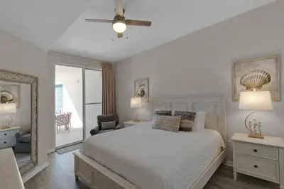 a white bedroom with a bed and a mirror at Bright Gulf-view condo with balcony pool seasonal beach service & pickleball in Santa Rosa Beach
