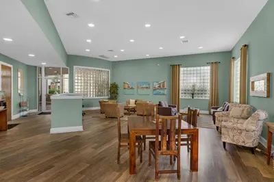 a living room with a table and chairs at Bright Gulf-view condo with balcony pool seasonal beach service & pickleball in Santa Rosa Beach