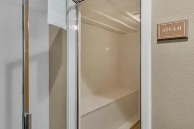 a walk in closet with a clear glass door at Bright Gulf-view condo with balcony pool seasonal beach service & pickleball in Santa Rosa Beach
