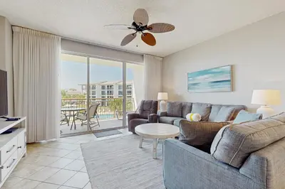 a living room with a couch and a table at Airy beachfront condo with balcony views lagoon pool tennis & pickleball in Seacrest