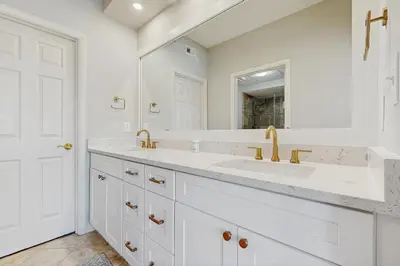 a white bathroom with two sinks and a mirror at Airy beachfront condo with balcony views lagoon pool tennis & pickleball in Seacrest