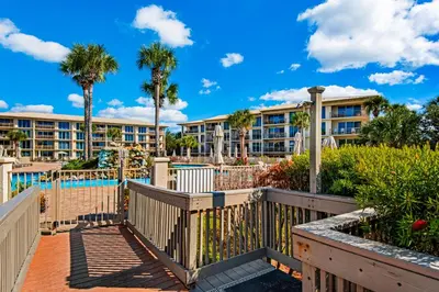 a resort with a pool and palm trees at Beautiful 3rd-floor villa with hot tub tennis pickleball & balcony with views in Seacrest
