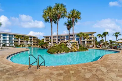 a swimming pool at a resort with palm trees at Amazing Santa Rosa Beach condo with pool hot tub & pickleball in Seacrest