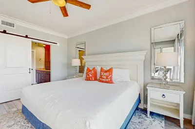 a bedroom with a white bed with red pillows at Amazing Santa Rosa Beach condo with pool hot tub & pickleball in Seacrest