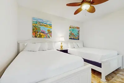 two beds in a bedroom with a ceiling fan at Amazing High Pointe condo with grill hot tub pool tennis & pickleball in Seacrest