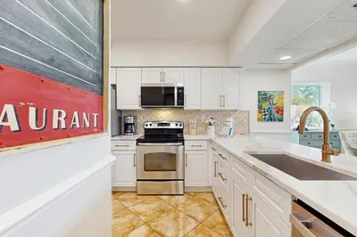 a kitchen with white cabinets and a sink at Amazing High Pointe condo with grill hot tub pool tennis & pickleball in Seacrest