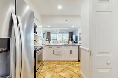 a kitchen with white cabinets and a stainless steel refrigerator at Amazing High Pointe condo with grill hot tub pool tennis & pickleball in Seacrest