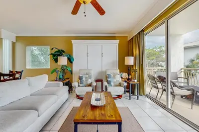 a living room with a couch and a table at Lovely condo with pool hot tub modern furnishings pickleball - near beach in Seacrest
