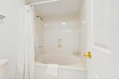 a white bathroom with a tub and a shower at Spacious getaway with Gulf view beach access tennis & pickleball in Seacrest