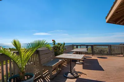 a wooden deck with a table and benches on the beach at Spacious getaway with Gulf view beach access tennis & pickleball in Seacrest