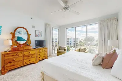 a bedroom with a bed and a mirror and a window at Spacious getaway with Gulf view beach access tennis & pickleball in Seacrest