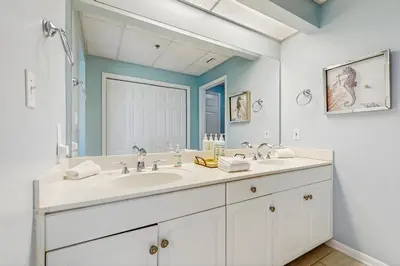 a bathroom with a sink and a large mirror at Conveniently located Gulf condo with spacious layout pool & pickleball in Seacrest