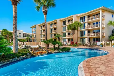 a resort with a swimming pool and palm trees at Conveniently located Gulf condo with spacious layout pool & pickleball in Seacrest