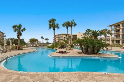 a swimming pool with palm trees and buildings at Conveniently located Gulf condo with spacious layout pool & pickleball in Seacrest