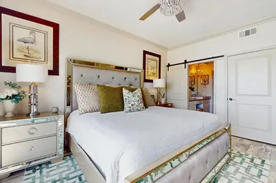a bedroom with a large white bed and a dresser at Condo with pickleball - steps from the Gulf & quick walk to dining & shops in Seacrest