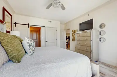 a bedroom with a white bed and a dresser at Condo with pickleball - steps from the Gulf & quick walk to dining & shops in Seacrest
