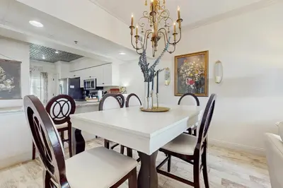 a dining room with a white table and chairs at Condo with pickleball - steps from the Gulf & quick walk to dining & shops in Seacrest