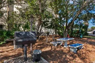 a park with a bench and a piano and a picnic table at Gulf-front condo with bicycles lazy river & pickleball in Seacrest