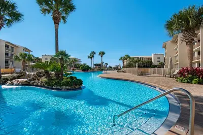 a swimming pool at a resort with palm trees at Elegant getaway with stunning view lagoon pool & pickleball - close to shops in Seacrest