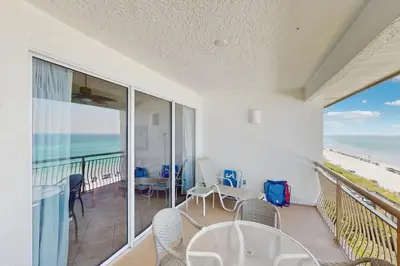 a room with a balcony with a view of the beach at Gorgeous beach condo with furnished balcony panoramic view & pickleball in Seacrest