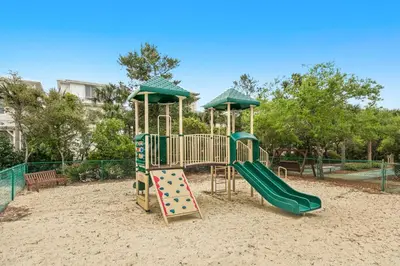 a playground with a slide in the sand at Gorgeous beach condo with furnished balcony panoramic view & pickleball in Seacrest