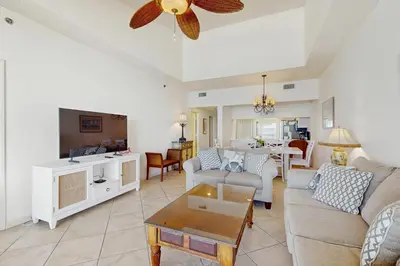 a living room with a couch and a table at Gorgeous beach condo with furnished balcony panoramic view & pickleball in Seacrest