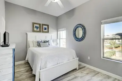 a white bedroom with a bed and a window at Beautiful 2nd-floor condo in Seagrove Beach with beach ambience & pickleball in Santa Rosa Beach