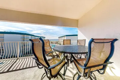 a balcony with a table and chairs on a balcony at Lovely home with pool & Gulf views covered parking bikes & pickleball in Santa Rosa Beach