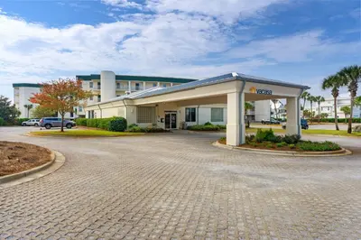 a building with a parking lot in front of it at Lovely home with pool & Gulf views covered parking bikes & pickleball in Santa Rosa Beach