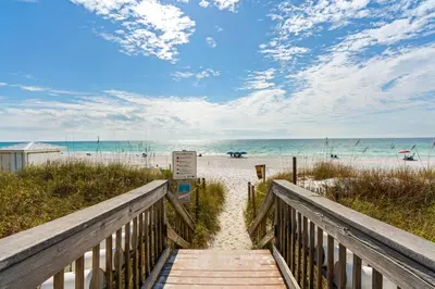 a boardwalk to the beach with the ocean in the background at Gulf-front view & spacious condo with wraparound balcony & pickleball in Santa Rosa Beach