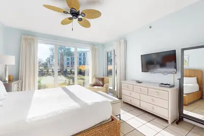 a bedroom with a bed and a flat screen tv at Beachfront condo with 2 beach chairs included & pickleball - short walk to dining in Seacrest