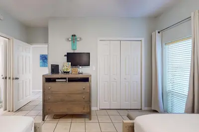 a bedroom with a dresser with a tv on it at Beachfront condo with 2 beach chairs included & pickleball - short walk to dining in Seacrest