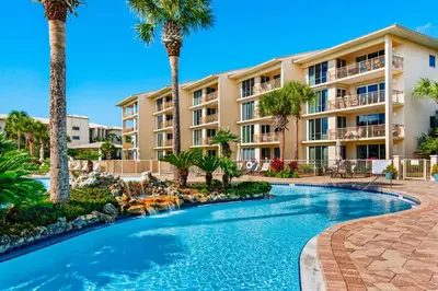 a resort with a swimming pool and palm trees at Beachfront condo with 2 beach chairs included & pickleball - short walk to dining in Seacrest